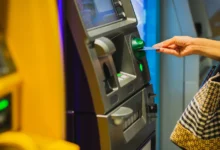 ATM cihazına banka kartı takan kadın.