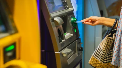 ATM cihazına banka kartı takan kadın.